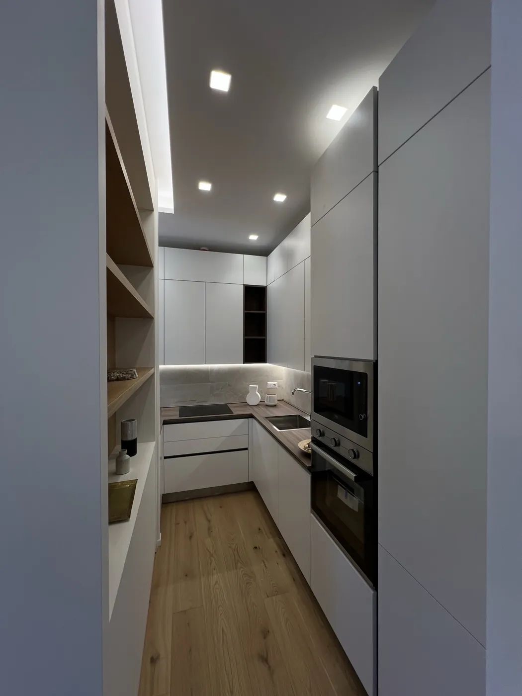 Cucina a U con colonne a filo, mensole in rovere e faretti incassati, Roma Corso Francia