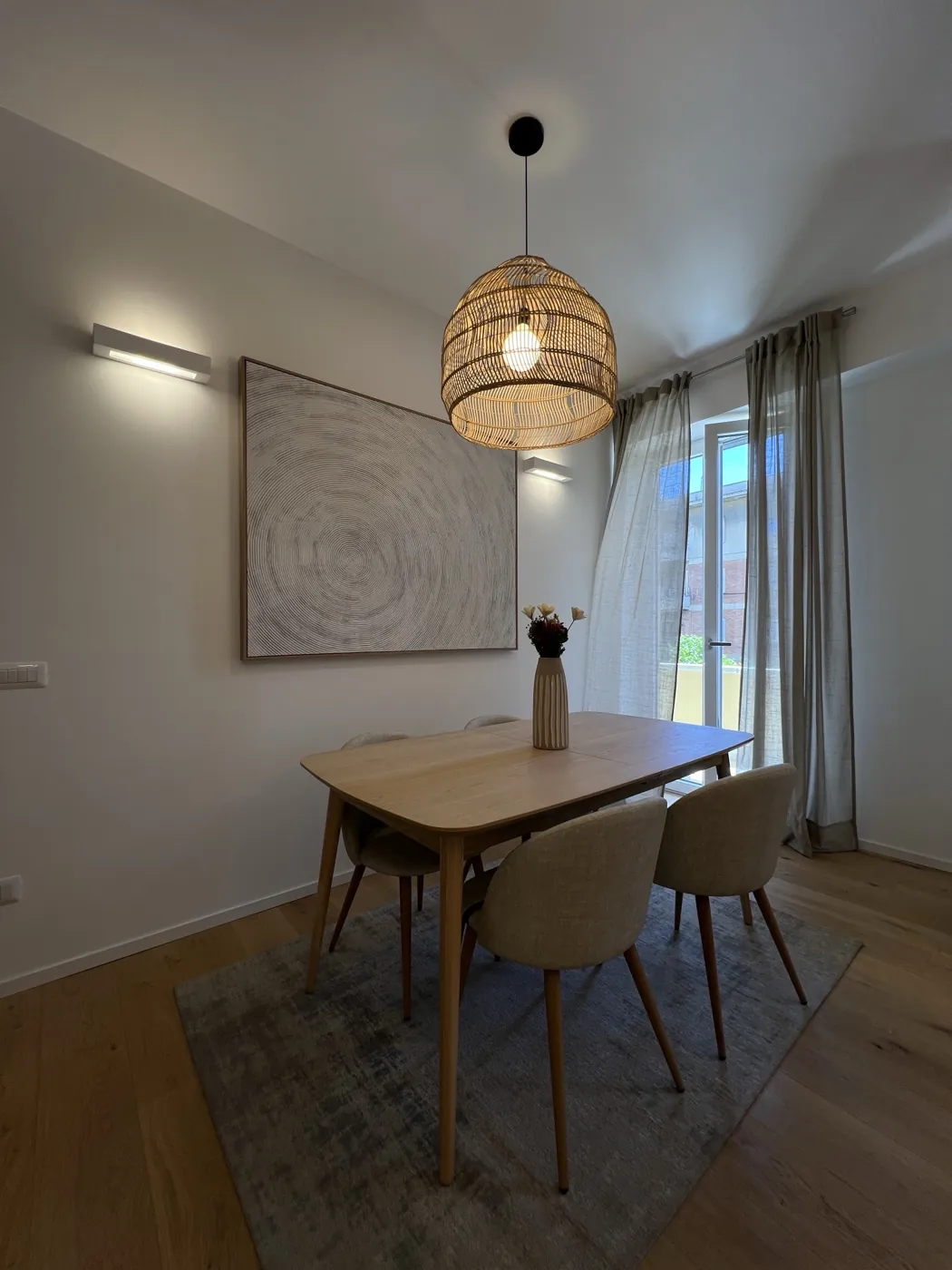 Zona pranzo con applique a parete, lampada in rattan e parquet in rovere, Roma Corso Francia